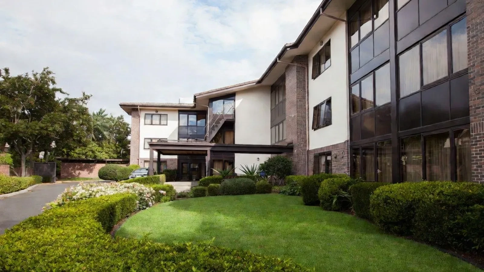 Modern residential apartment building with lawn and hedges
