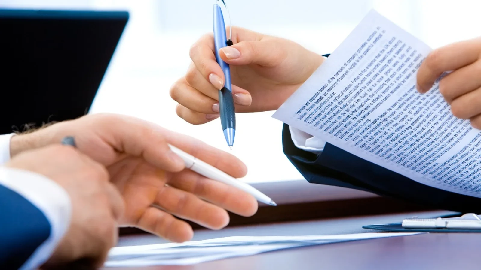 Two people reviewing documents and invoices at a desk