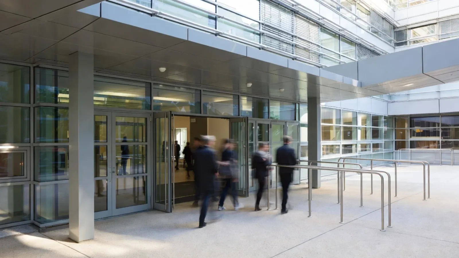 Modern office entrance with glass doors and people