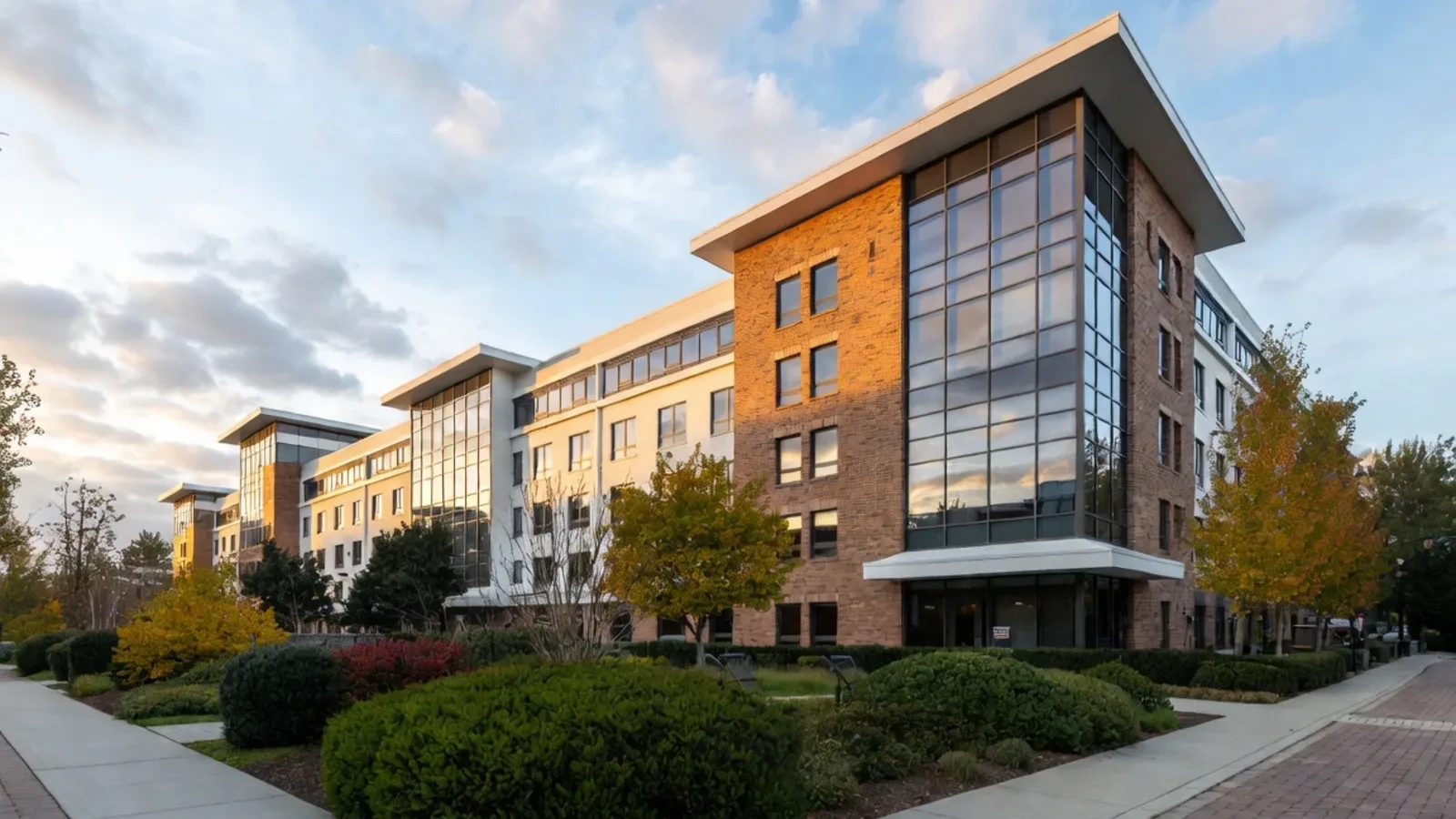 Modern campus building with brick and glass at sunset