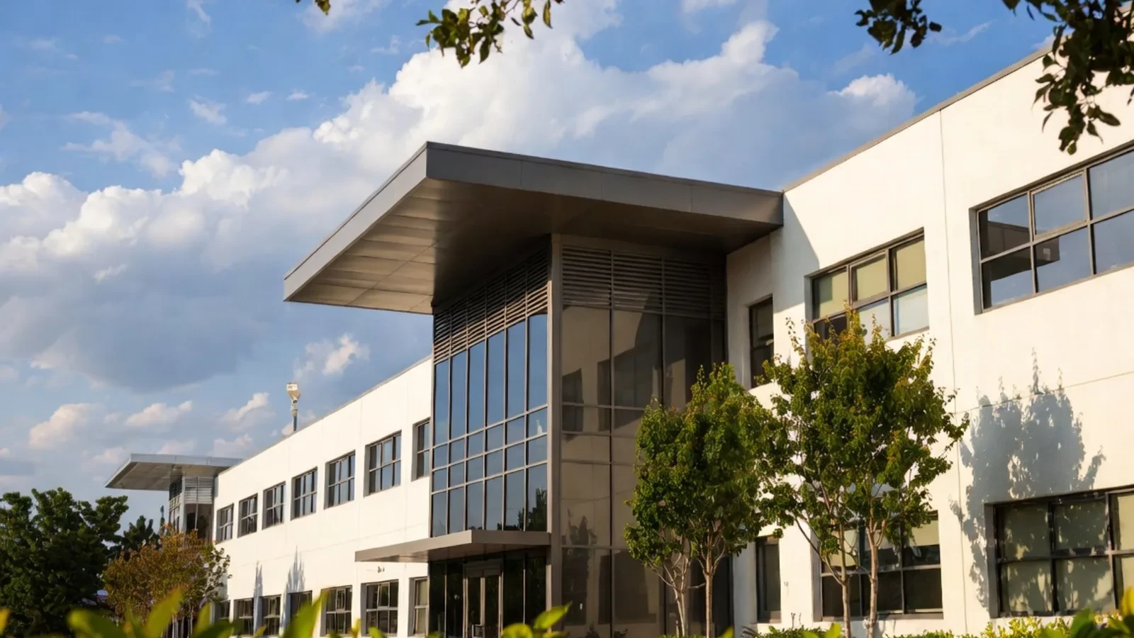 Modern white office with glass atrium and trees